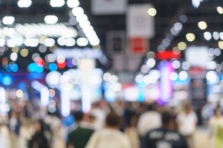Gran feria empresarial con multitud de visitantes recorriendo los stands y luces del recinto