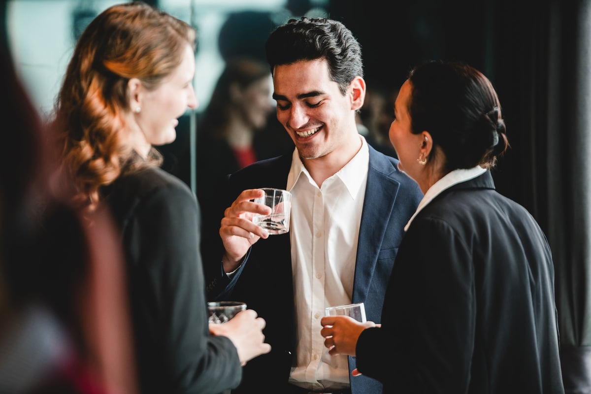 Business professionals gather after work for drinks and casual conversation, showing teamwork, connection, and positive workplace culture.