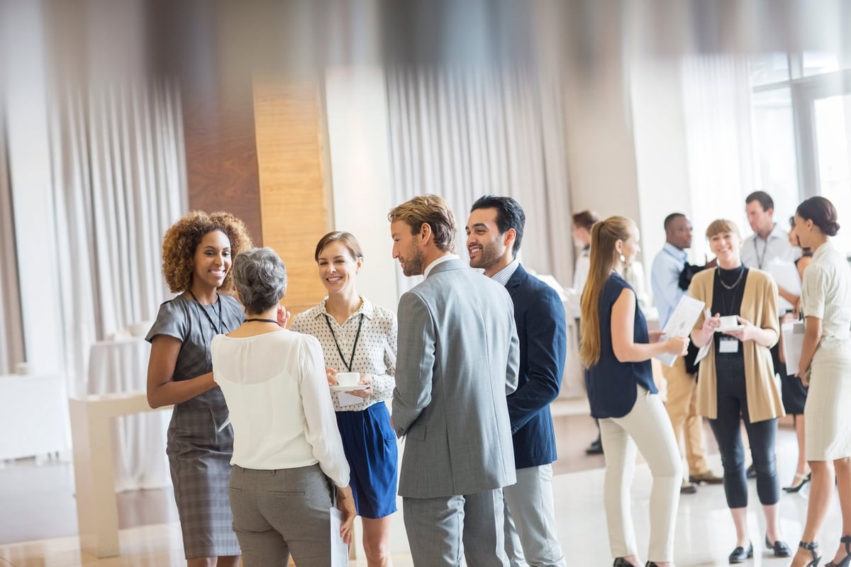 Grupo diverso de profesionales haciendo networking en un evento empresarial moderno