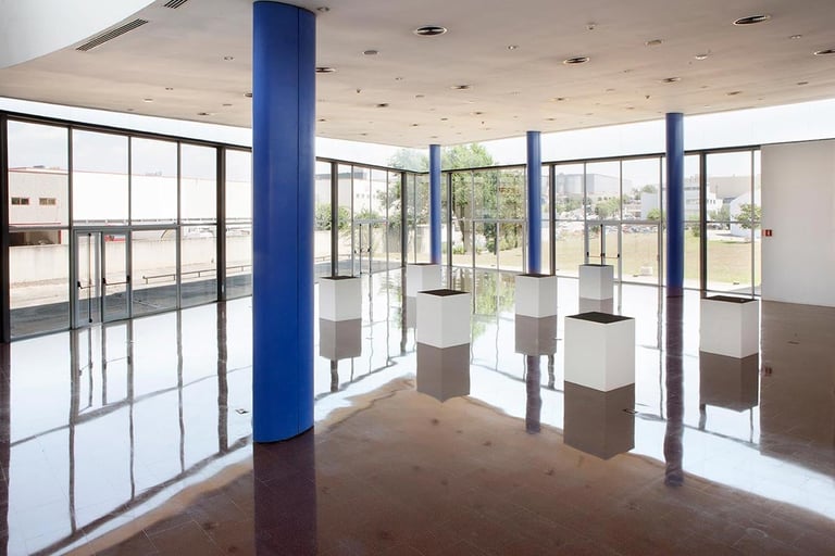 Empty retail or commercial space with blue support columns, large windows, and polished floor